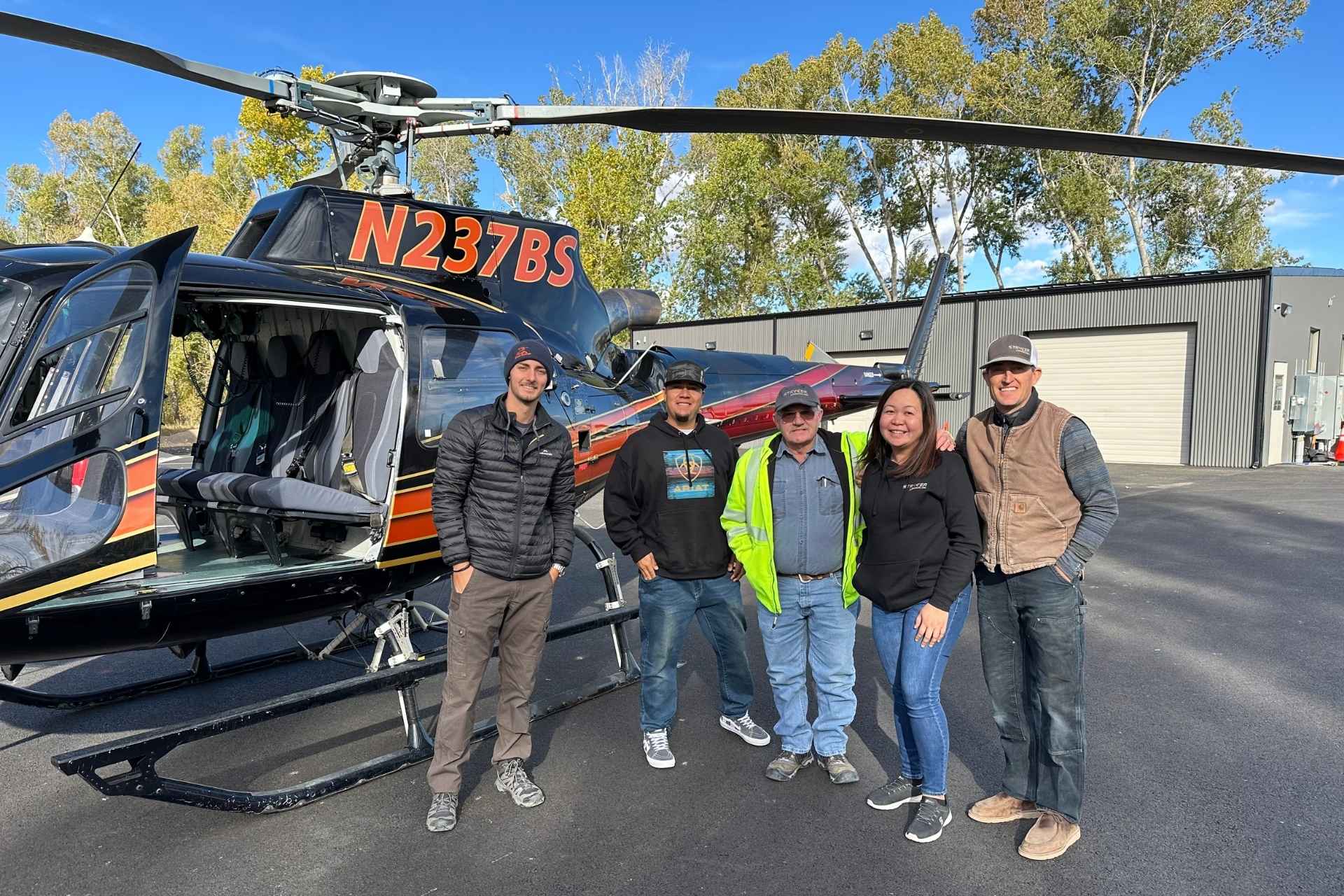 Stryker employees standing next to a helicopter